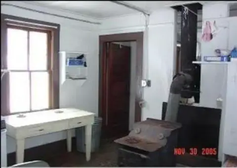 Interior view of a room with a stove and a desk.