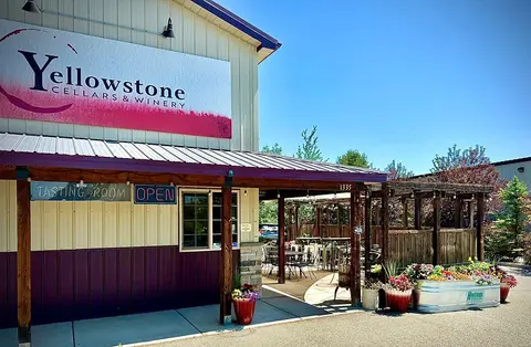 Exterior of a winery building with a tasting room and outdoor seating.