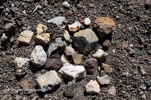 A collection of various rocks and minerals scattered on the ground.