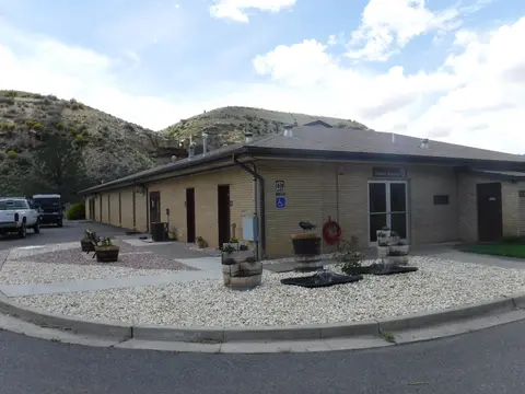 A single-story brick building with a visitor display entrance and landscaping.