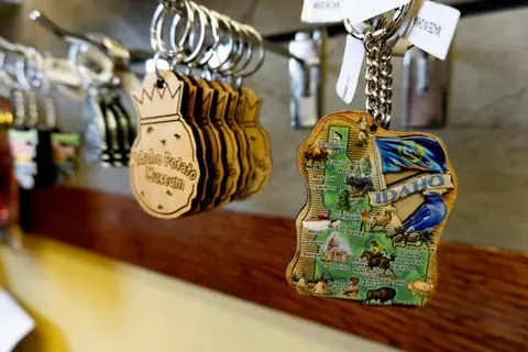 A close-up shot of keychains hanging on a display rack inside a gift shop.