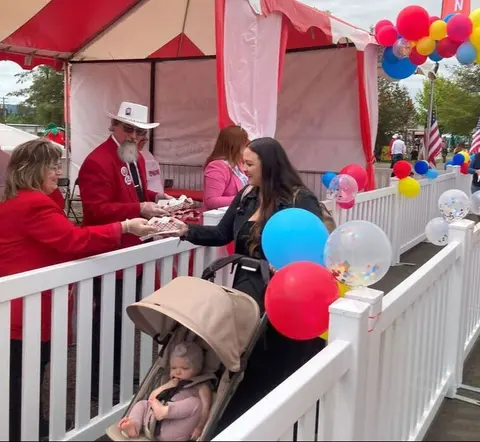 People at a tent receiving food at an event.