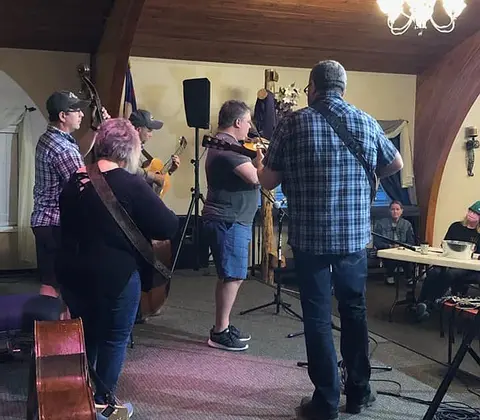 A band plays acoustic music indoors.