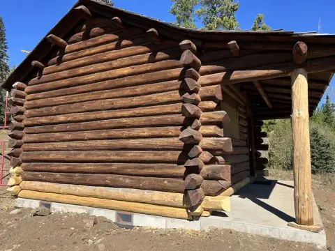 Exterior view of a rustic log cabin with a covered porch.