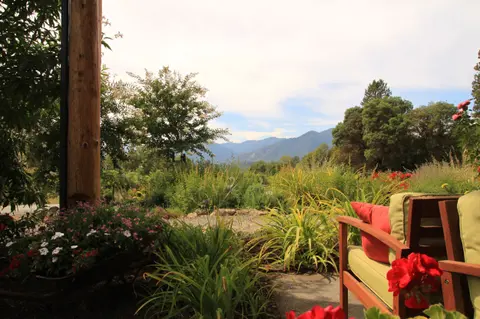 A view of distant mountains and a garden from a porch.