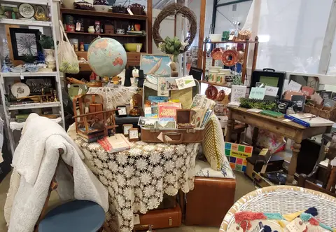 An interior view of a room filled with vintage items, furniture, and decorative objects.