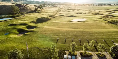 An aerial view of a golf course nestled among rolling hills.