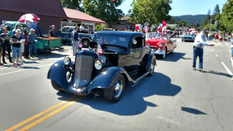 Classic cars participate in a street parade.