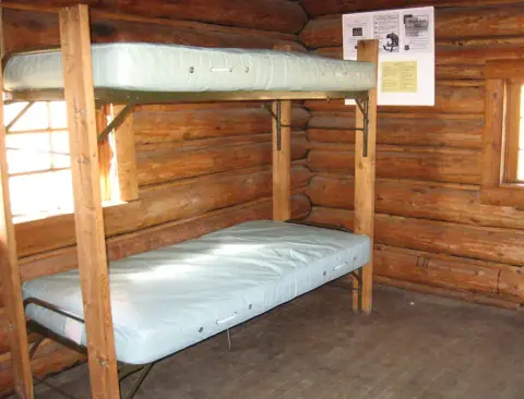 A bunk bed inside a log cabin.