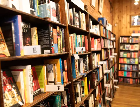 Wooden bookshelves filled with books inside a bookstore.