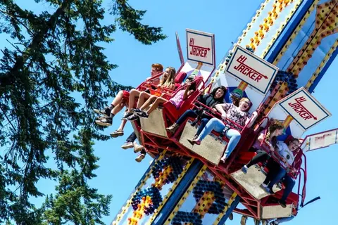 People riding an amusement park ride outdoors.