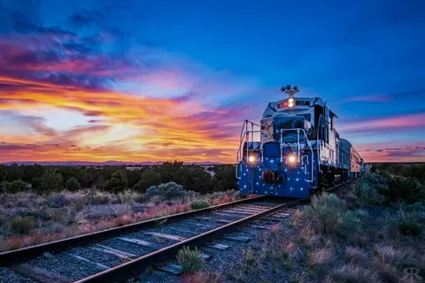 A train on tracks during a colorful sunset.