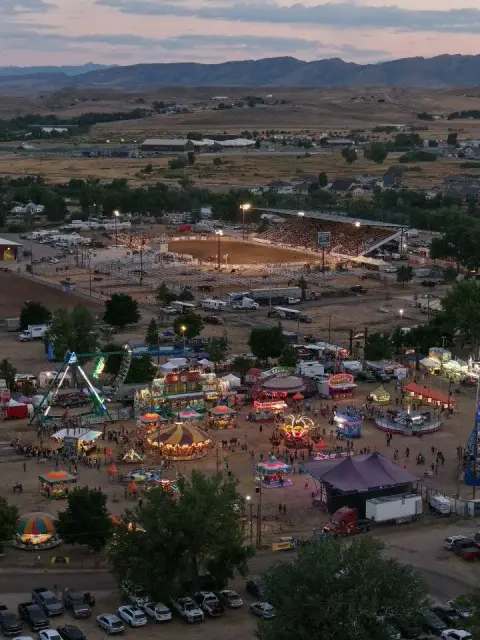 An elevated view of a fairground and rodeo arena at dusk.