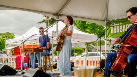 A band performs under a tent outdoors.