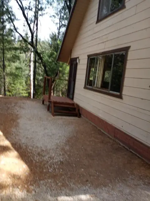 An exterior view of a house next to a forest.
