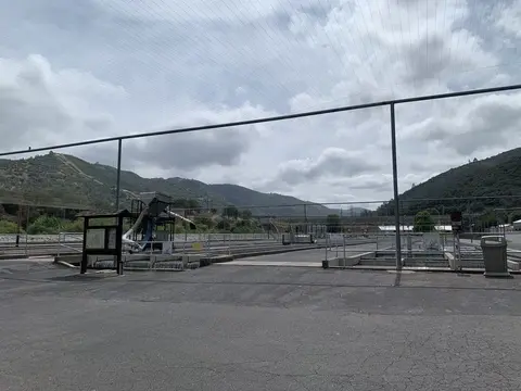 An outdoor view of a fish hatchery facility with raceways and mountains in the background.