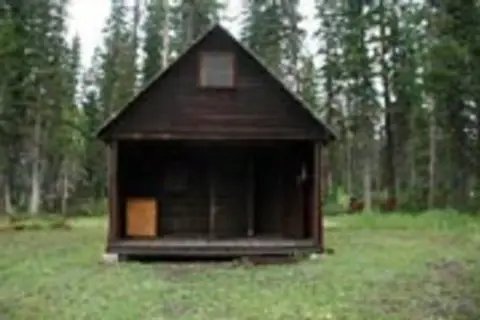 A small wooden cabin in the woods.