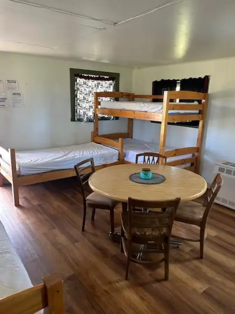An interior view of a bedroom with bunk beds and a dining table.