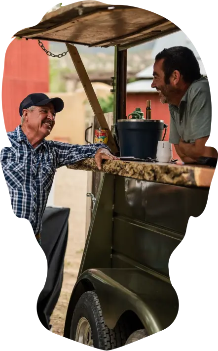 Two men talking at a counter.