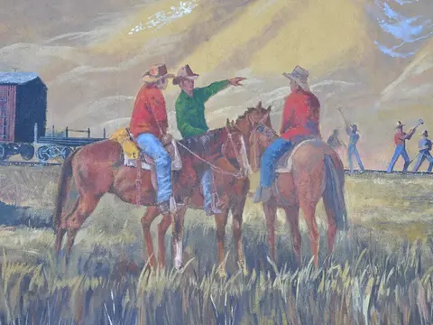 A painting depicts cowboys on horseback outdoors near railway tracks.
