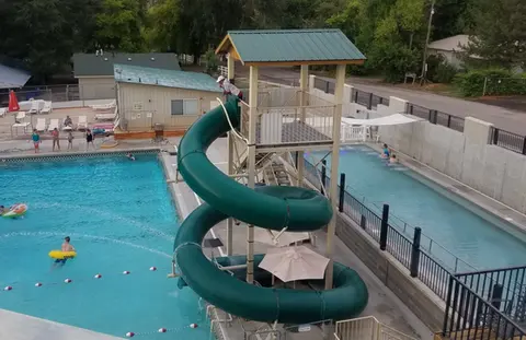 An outdoor swimming pool with a large spiral water slide.