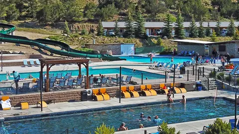 An elevated view of an outdoor swimming pool complex with water slides and resort buildings.