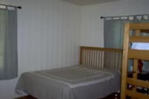 A bedroom with a bed and a bunk bed.
