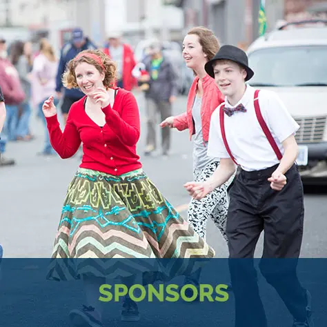 People dancing together outdoors at a crowd event.
