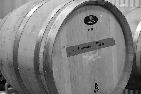 A wooden wine barrel is shown in a black and white close-up.