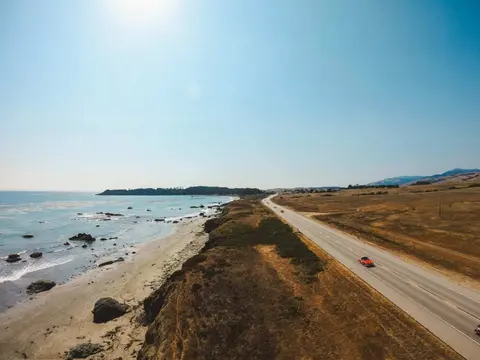 Aerial view of a coastal road next to a beach and ocean.