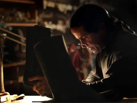 A person working on leather boots in a workshop.