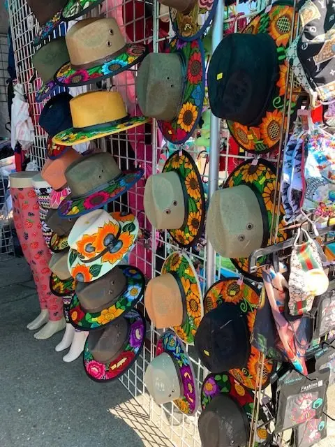 A display rack filled with colorful hats decorated with floral patterns.