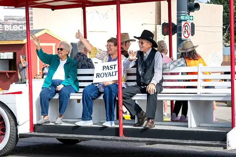 People wave from a parade float.