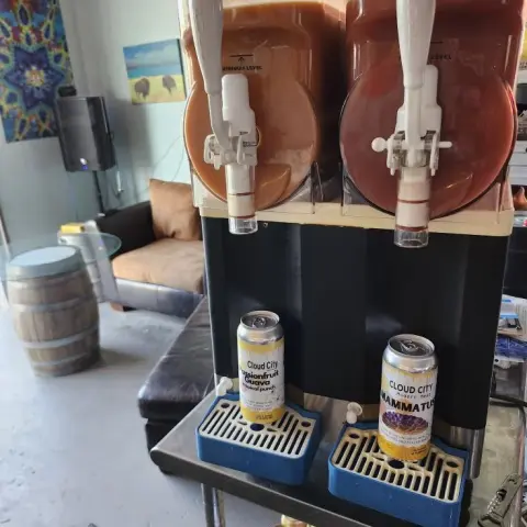 A slush drink machine stands on a counter indoors.
