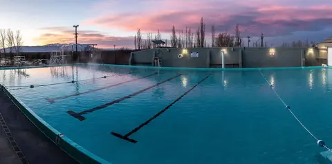 An outdoor swimming pool at sunrise.