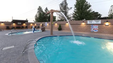 An outdoor pool area with a water feature shaped like a pickaxe.