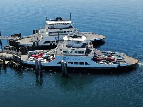 An aerial view of two ferries docked at a pier.