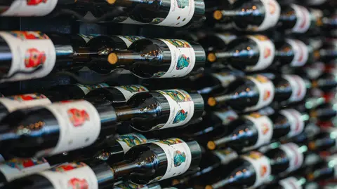 A wall filled with rows of bottled wine on racks.