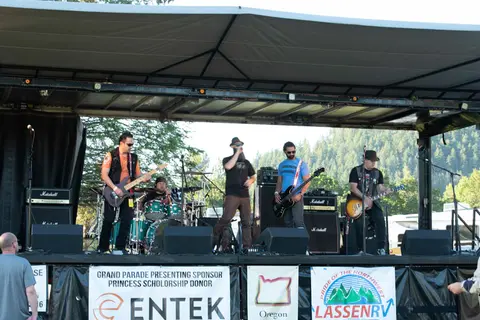 A band performs on an outdoor stage under a canopy.