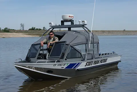 A person in a state park patrol boat on the water.