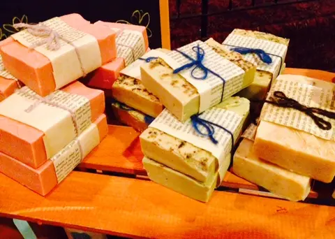 A display of handmade soaps wrapped in paper and tied with twine.
