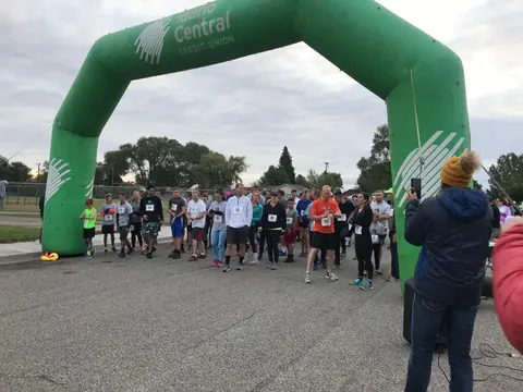 A group of runners gather under an inflatable archway before a race.