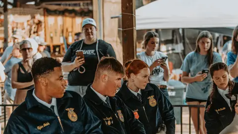 People in matching jackets sit together at an event.