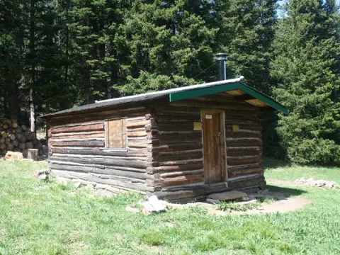 A rustic log cabin nestled in a forest.