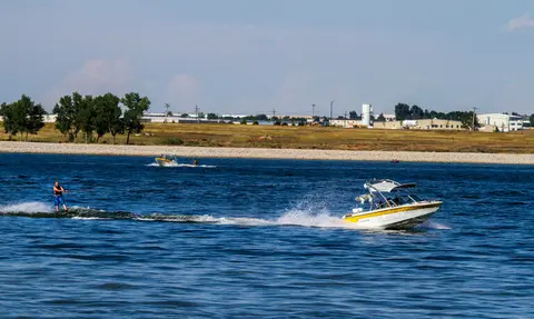 A person waterskiing behind a motorboat on a lake.