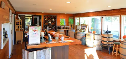 An interior view of a rustic tasting room with wooden walls and a counter.