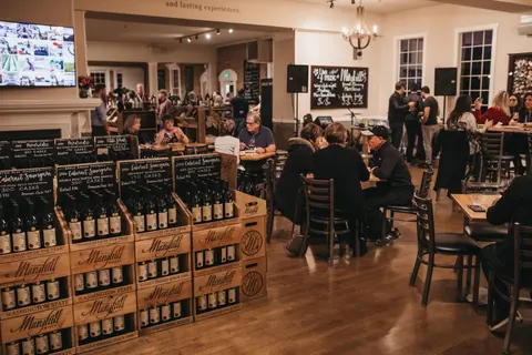 People tasting wine in a crowded tasting room.
