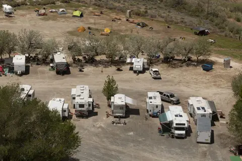 An aerial view shows an RV park and campground with many trailers and tents.