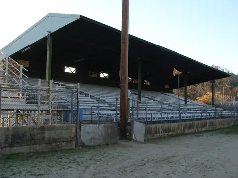 A covered grandstand with seating is seen from outside.