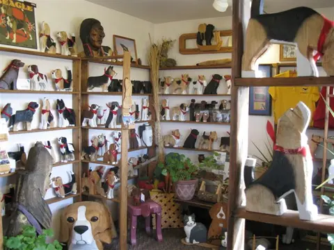 A gift shop interior filled with shelves of carved wooden dog sculptures.